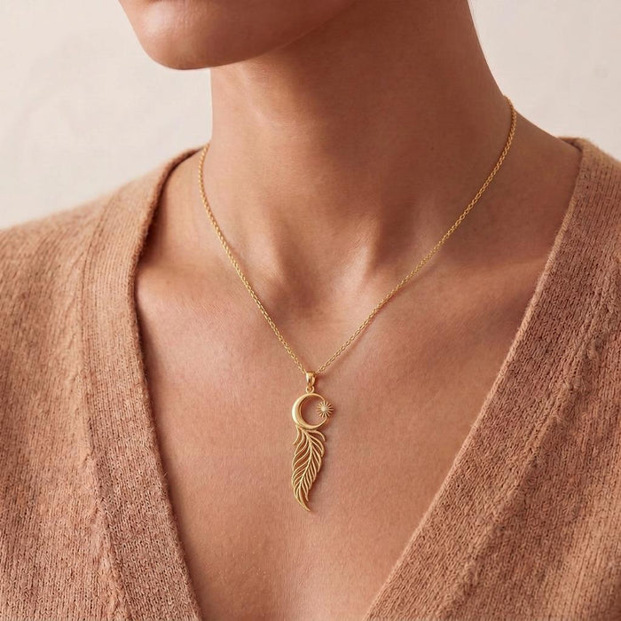 Gold Plated Silver Eclipse Feather Necklace worn at the collarbone with the crescent-and-feather pendant centered above a V-neckline