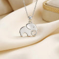 Close-up of a polished solid elephant pendant with circular eye detail and curled trunk on cream satin