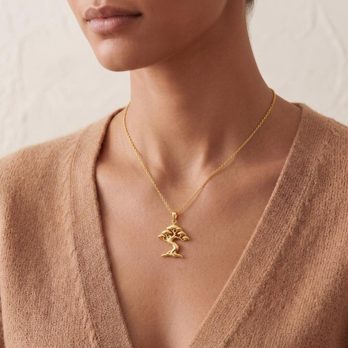 Gold Plated Silver Ficus Flow Necklace worn with a beige V-neck knit top