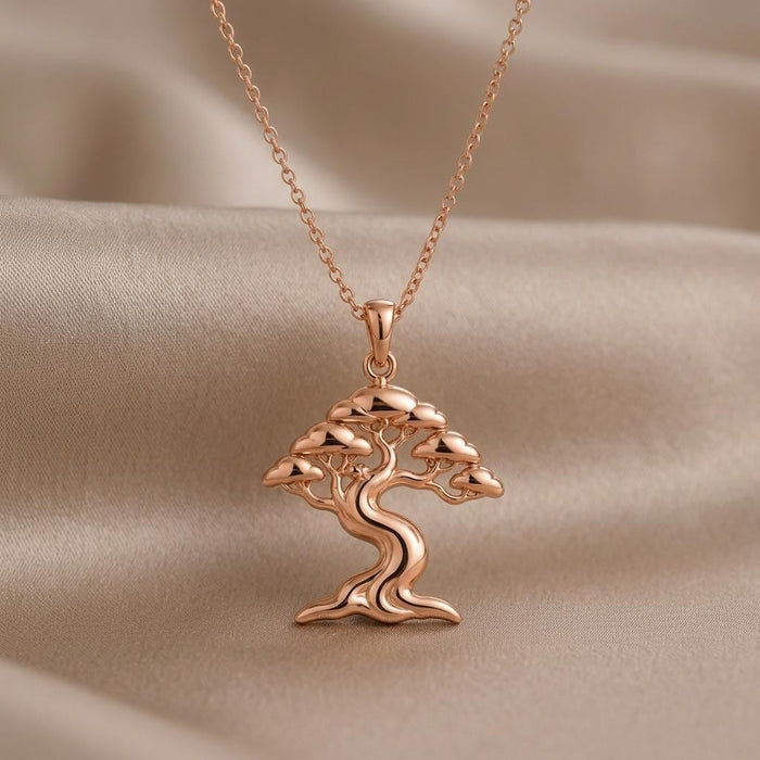 Close-up of a Rose Gold Plated Ficus Flow tree pendant with layered canopy and flared root base