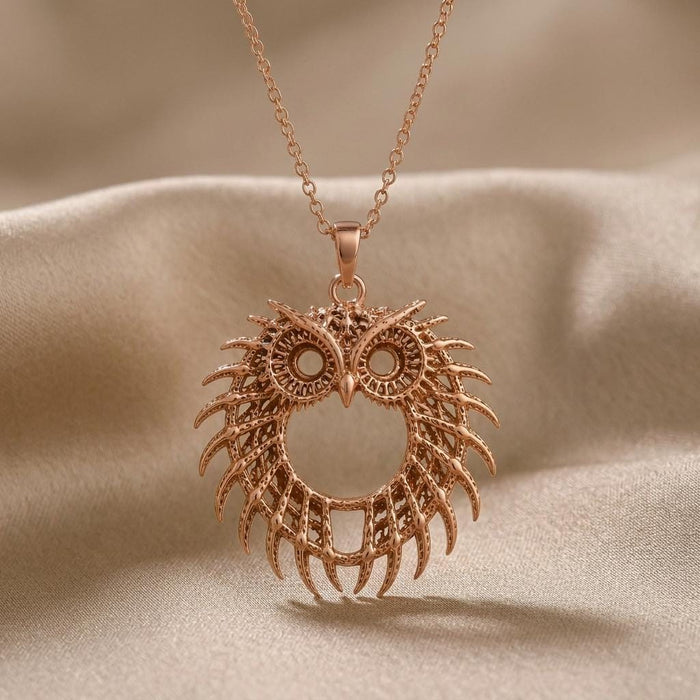 Rose Gold Plated Fossil Owl Halo pendant necklace close-up with layered feather-like openwork on beige satin