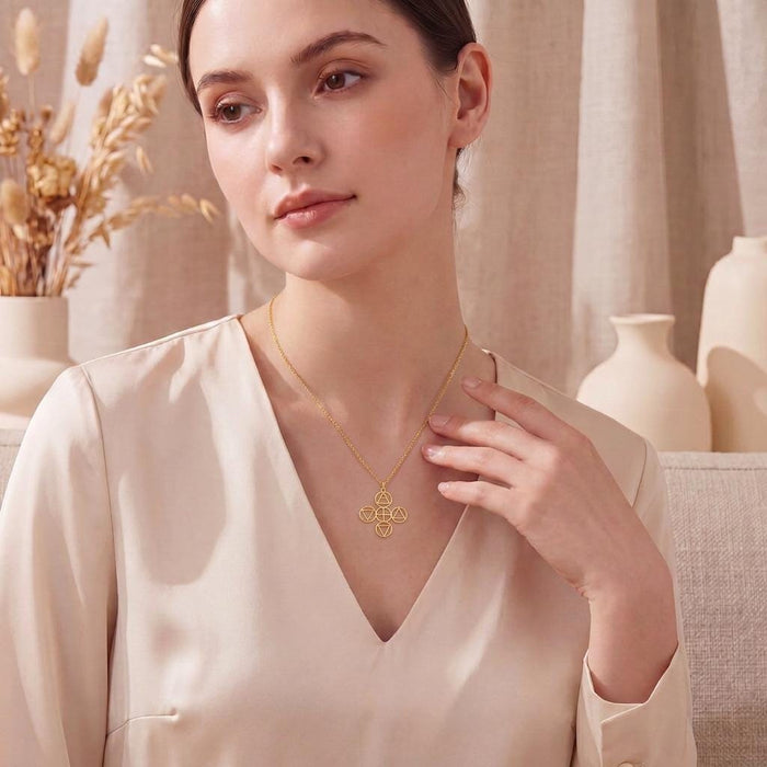 Lifestyle image of the Gold Plated Silver Four Elements Necklace worn with a cream V-neck blouse
