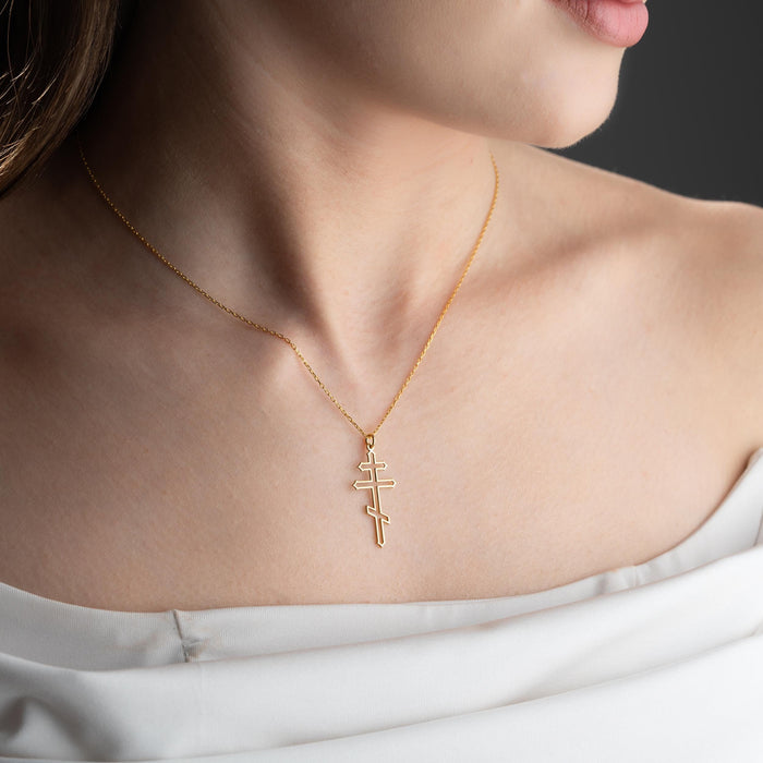 Gold Plated Silver three-bar cross necklace worn above an off-shoulder white top
