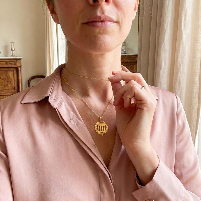 Model wearing a Gold Plated Silver Greek Temple Necklace layered with a second chain over a pink blouse