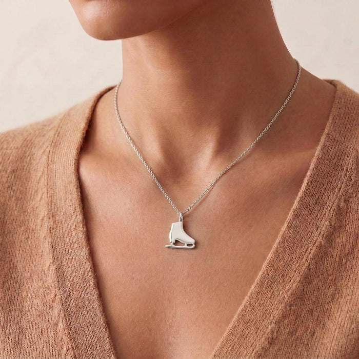 Ice skate silver necklace worn at the collarbone with a textured knit cardigan