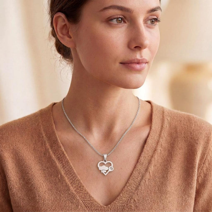 Model wearing the Love for Cooks heart pendant necklace with a warm-toned V-neck top