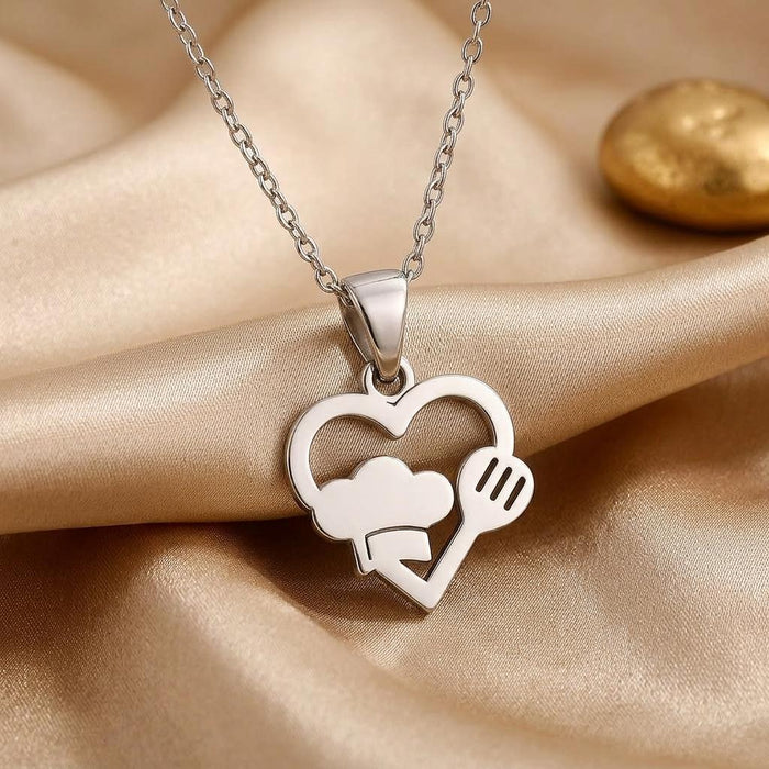 Front view of the open heart chef hat and fork pendant on champagne satin