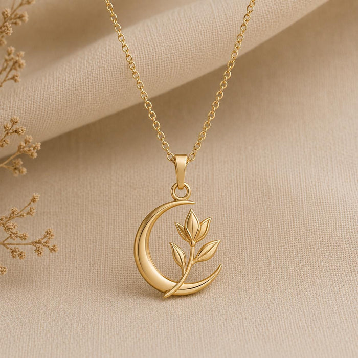 Gold Plated Silver Lunar Petal Pendant with an open crescent and three-leaf sprig on textured neutral fabric