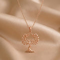 Rose Gold Plated Olive Crown Pendant Necklace with an openwork leafy tree on draped beige fabric