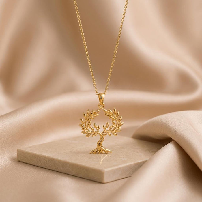 Gold Plated Silver Olive Crown Pendant Necklace with openwork tree displayed on a stone block
