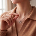 Model wearing a sterling silver openwork crab necklace with an oval center and raised claws