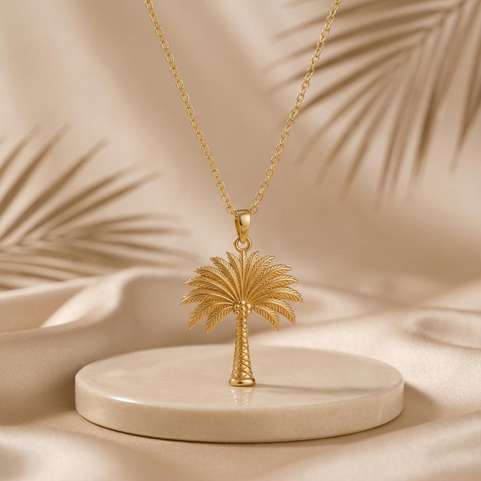 Gold Plated Silver Palm Crown Necklace on a round stone display with palm-leaf shadows