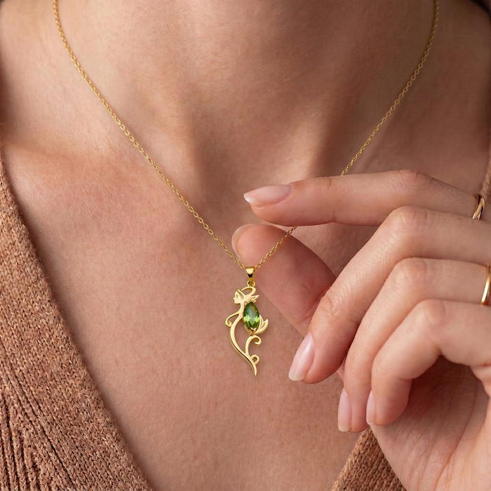 Gold Plated Silver Peridot Elf Necklace held at the neckline to show pendant scale