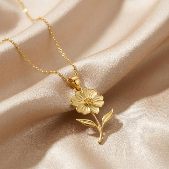 Close view of the Gold Plated Silver petunia pendant with curved stem and two pointed leaves on champagne satin