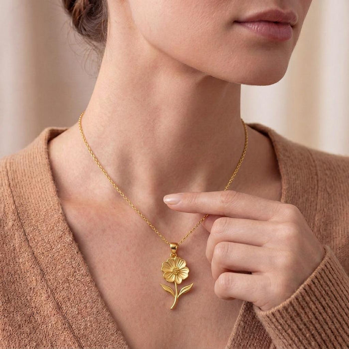 Gold Plated Silver Petunia Flower Necklace worn at the collarbone with a hand beside the pendant
