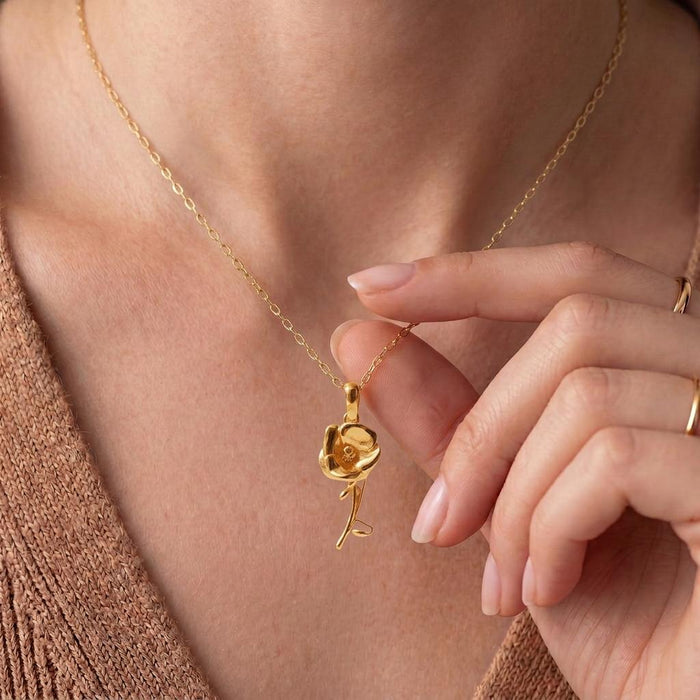 Gold Plated Silver Poppy Flower Necklace worn at the neckline, showing the flower pendant and curved stem