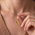 Gold Plated Silver Poppy Flower Necklace worn at the neckline, showing the flower pendant and curved stem