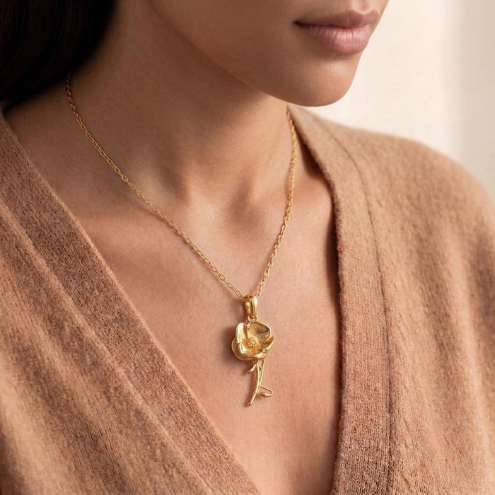 Cropped model view of a Gold Plated Silver flower pendant necklace worn with a V-neck knit top