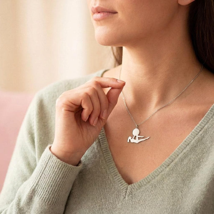 Reclining yoga pose necklace worn with a pale green V-neck sweater