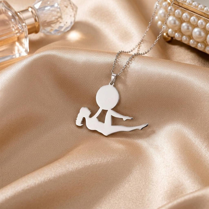 Reclining yoga figure pendant displayed on champagne satin beside pearl accessories