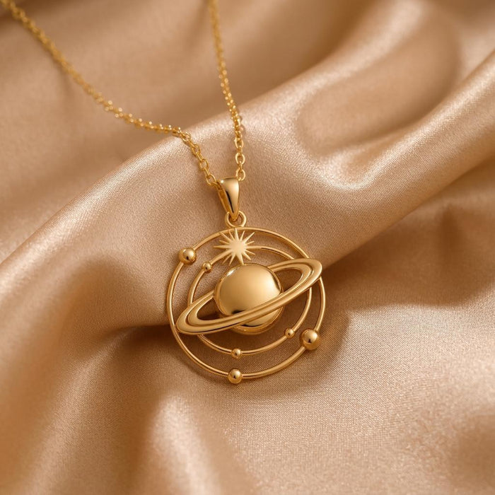 Gold Plated Silver Saturn Orbit Necklace with a ringed planet and orbital frame on champagne satin