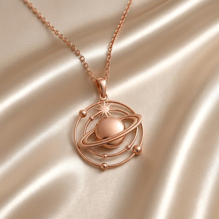 Rose Gold Plated Saturn Orbit Necklace with ringed planet pendant on pale satin