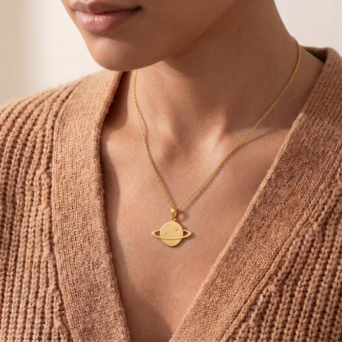 Close view of a Gold Plated Silver Saturn Ring Necklace worn with a textured tan cardigan