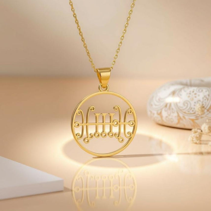 Gold Plated Silver circular Seal of Sallos pendant hanging from its chain on a styled surface