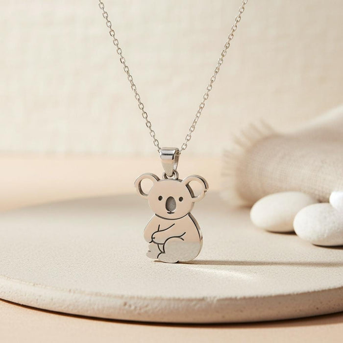 Silver Koala Necklace with seated koala pendant on a textured neutral display surface