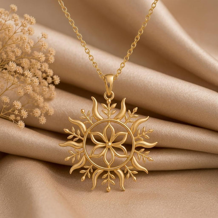 Close view of the Gold Plated Silver Solstice Bloom pendant necklace on champagne satin with floral center and curved rays