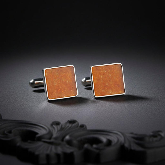 Front-facing pair of square amber cufflinks with warm orange-toned center panels