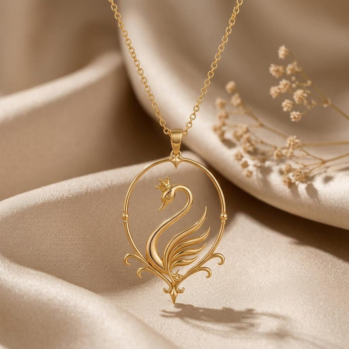 Gold Plated Silver crowned swan pendant with layered wing lines on draped champagne satin