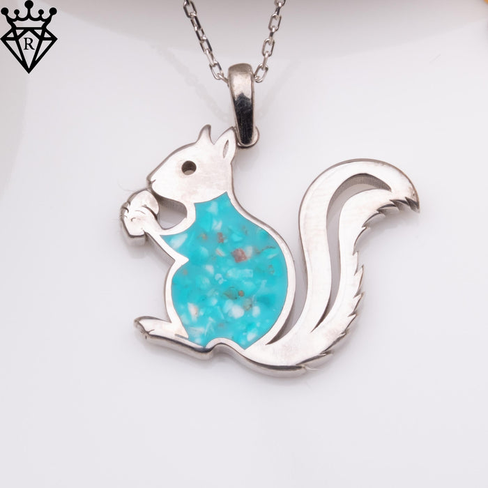 Front view of a seated squirrel pendant with a turquoise body and raised tail