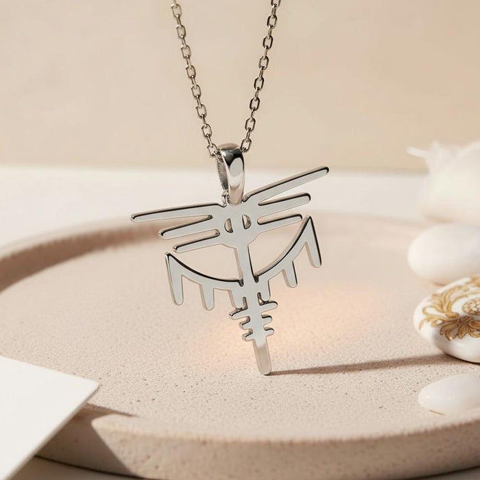 Silver pendant necklace displayed upright on a round neutral tray