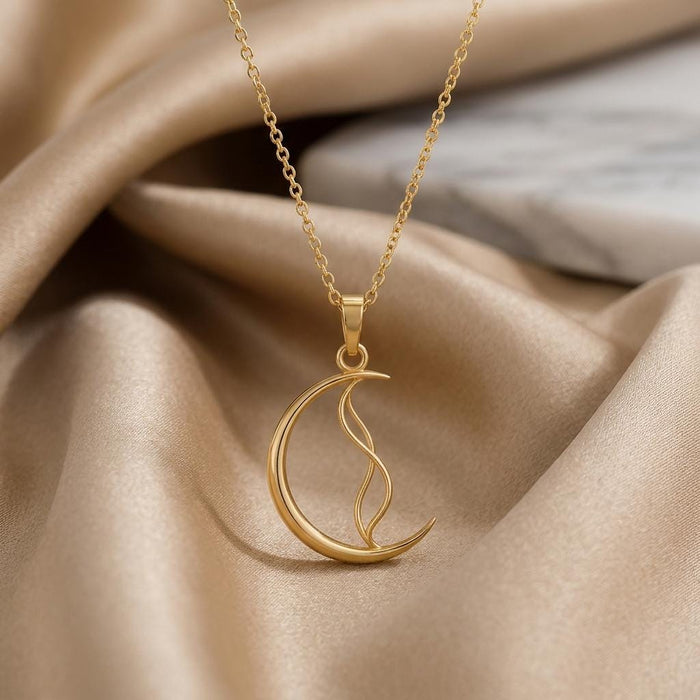 Close-up of the gold-finish Whisper Crescent Pendant showing its open crescent and flowing inner line