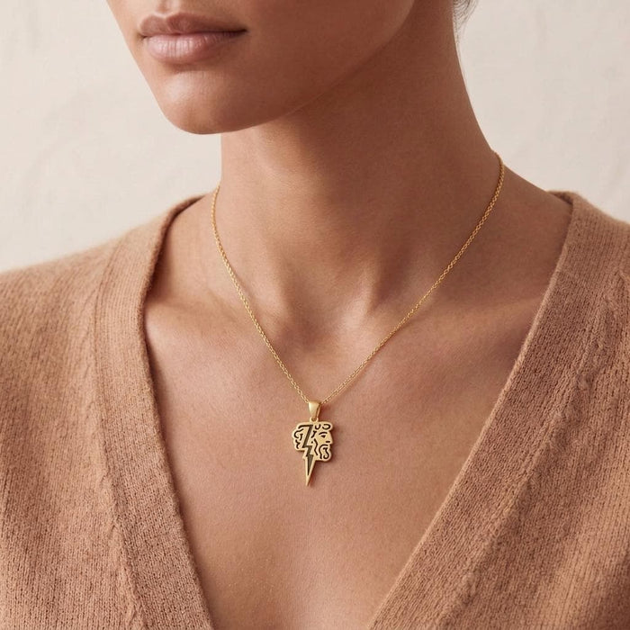 Gold Plated Silver Zeus Lightning Necklace worn with a beige knit top, showing the Zeus profile and pointed lightning bolt pendant