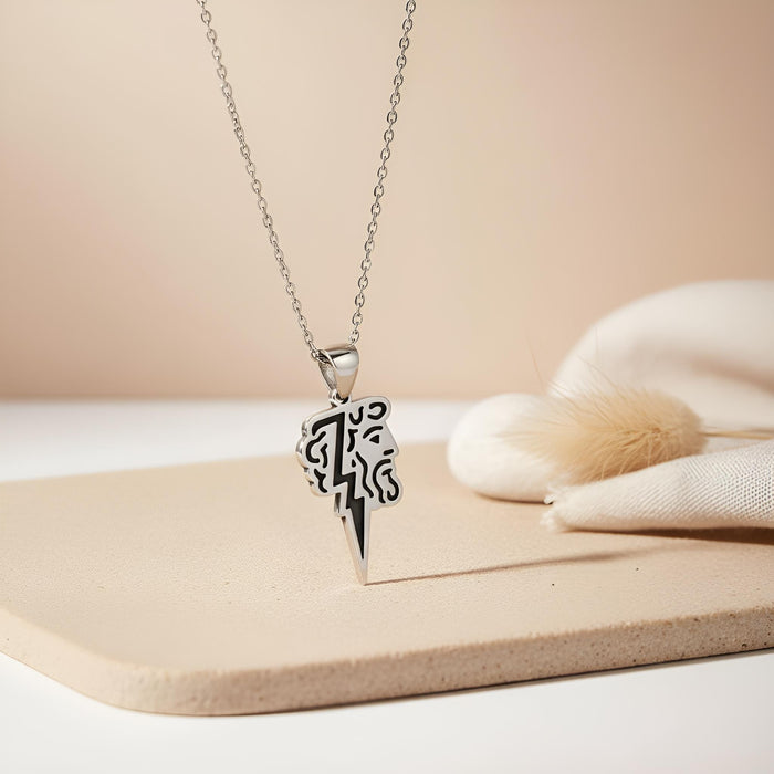 Silver Zeus Lightning Necklace on a neutral display surface with a stylized Zeus profile and pointed lightning bolt pendant