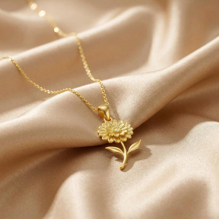 Gold Plated Silver zinnia pendant with layered petals displayed on champagne satin