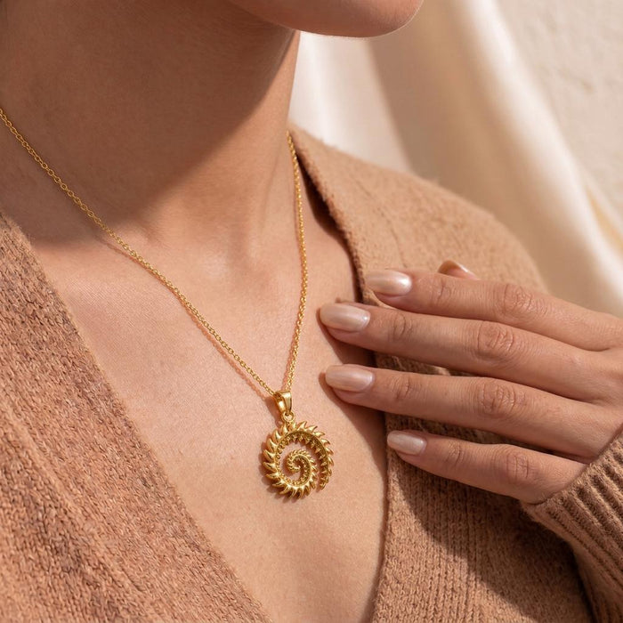 Close view of Gold Plated Silver Helicoprion spiral tooth pendant necklace worn at the neckline