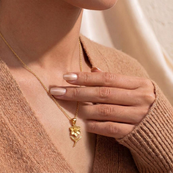 Gold Plated Silver Hellebore Flower Necklace worn with a tan knit cardigan
