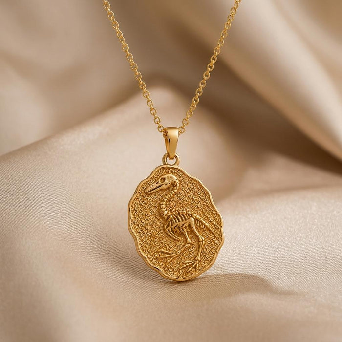 Gold Plated Silver Hesperornis Fossil Pendant with raised bird skeleton relief on champagne satin
