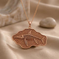 Rose Gold Plated Ichthyosaurus fossil pendant necklace with skeletal relief on a textured irregular plaque