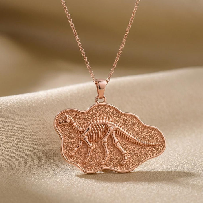 Close-up of Rose Gold Plated Iguanodon skeletal relief on a textured irregular fossil-style plaque