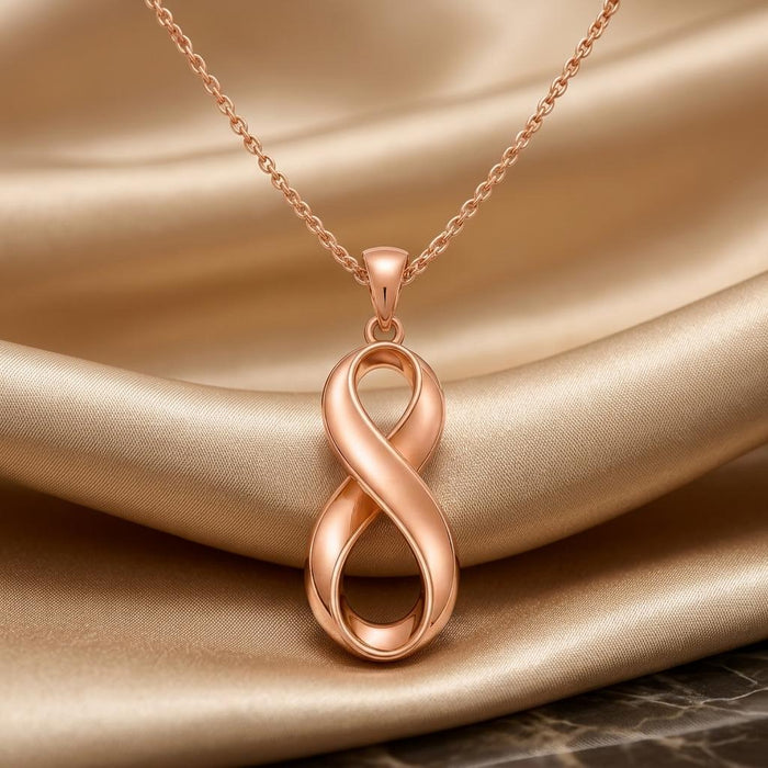 Rose-tone Infinity Fold pendant displayed on draped satin