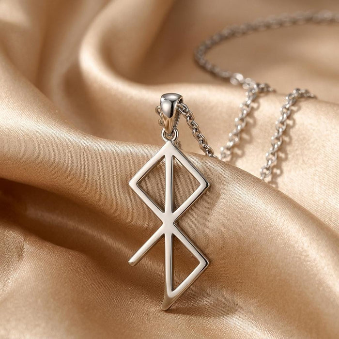 Silver Inner Peace Rune Necklace close-up on champagne satin showing the upper diamond-shaped and lower triangular cutouts