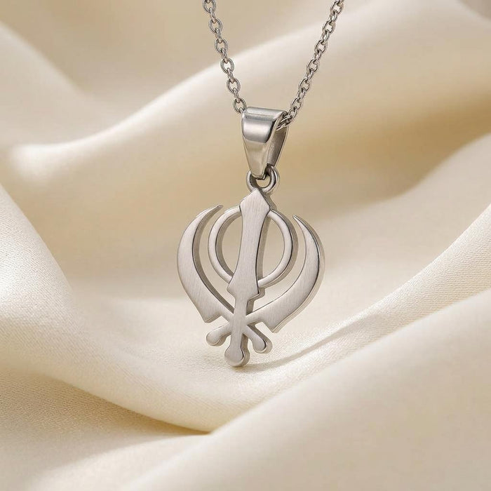 Detailed view of the openwork Khanda pendant on cream fabric