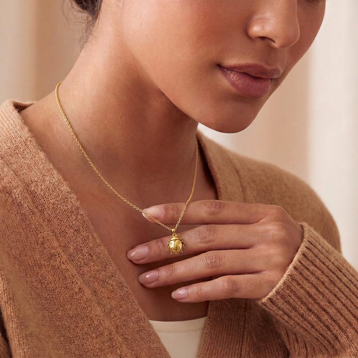 Ladybug Necklace in Gold Plated Silver worn at the collarbone with a hand near the pendant
