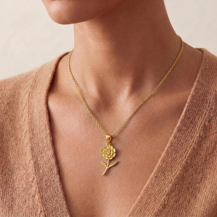 Gold Plated Silver floral necklace worn at the collarbone with a beige V-neck sweater
