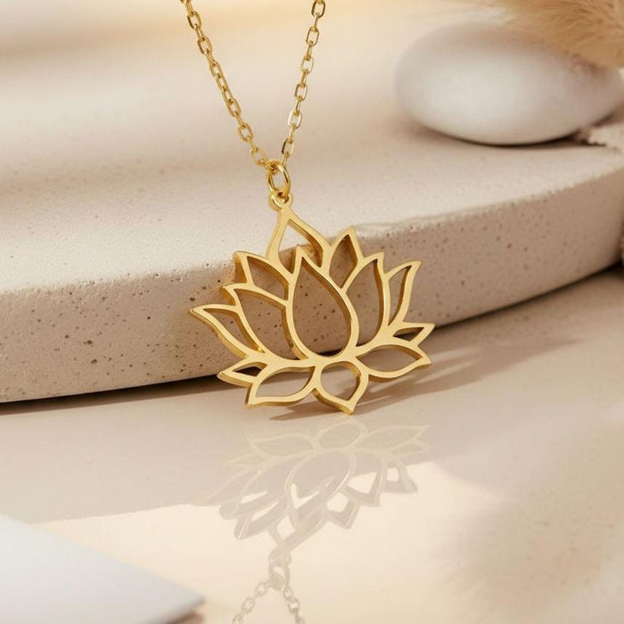 Gold Plated Silver Lotus Flower Necklace close-up with reflection on a cream surface