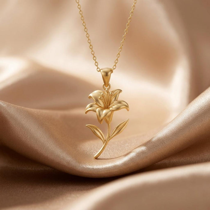 Gold Plated Silver lily pendant necklace with sculpted petals, curved stem, and two leaves on champagne satin